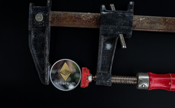 Ethereum coin held in a metal clamp