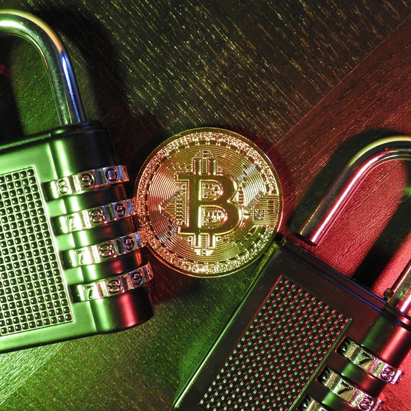 Bitcoin coin beside a combination padlock