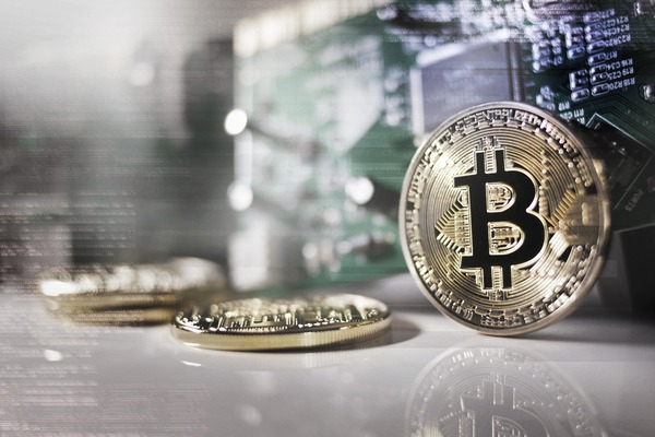 Silver Bitcoin coin standing on a reflective surface