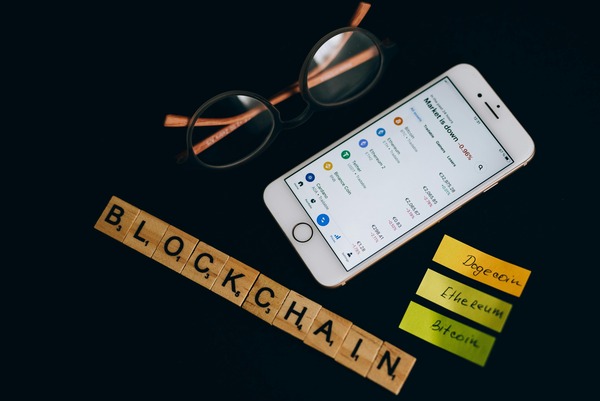 Smartphone and blockchain letter tiles on a dark desk