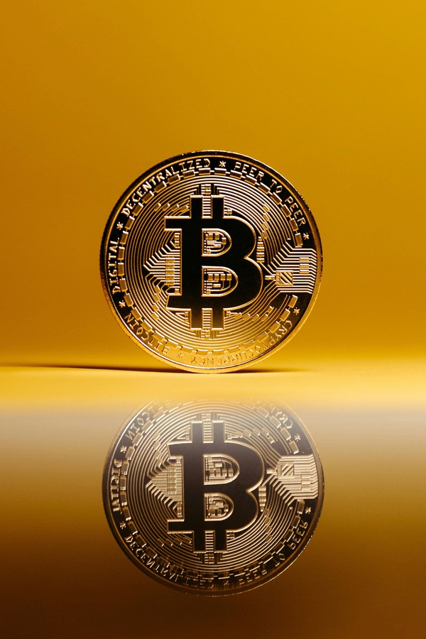 Gold coin reflected on a polished golden surface