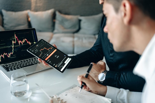 Two people reviewing a crypto chart on a tablet