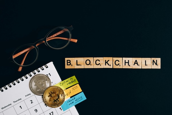 Calendar and coins beside blockchain letter tiles