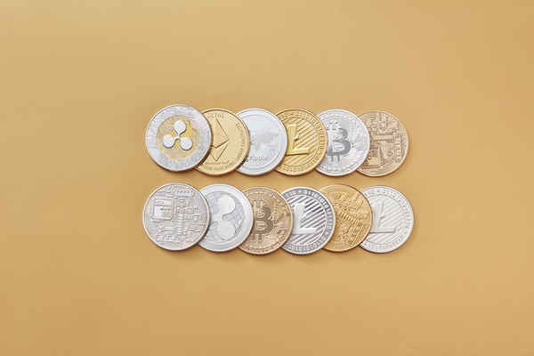Rows of assorted crypto coins on a beige background