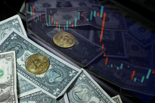 Gold crypto coins on dollar bills over a market chart