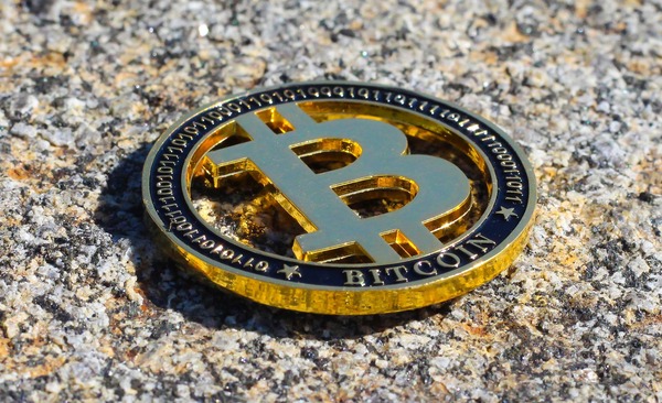 Physical Bitcoin coin lying on a granite surface