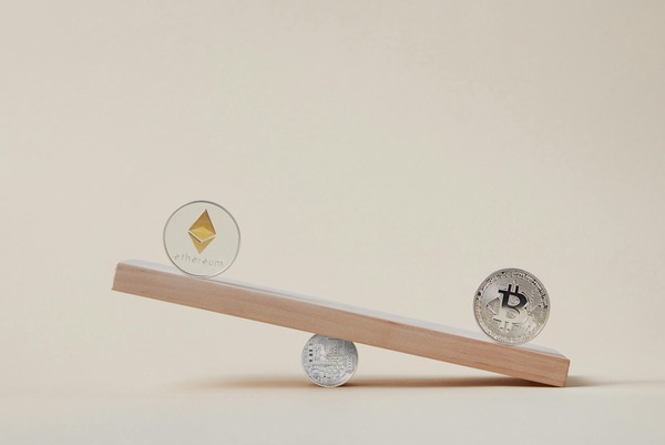 Crypto coins balanced on a wooden seesaw
