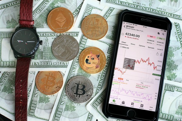 Phone with a crypto trading app on coins and dollar bills