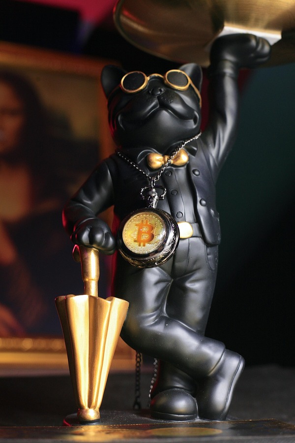 Golden figurine holding crypto coins on a dark background