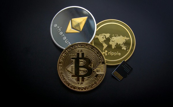 Bitcoin, Ethereum and Ripple coins on a dark background