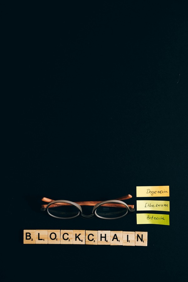 Blockchain letter tiles with glasses on a dark desk