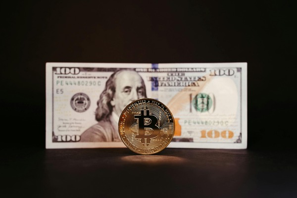 Hundred-dollar bill with a crypto coin on a dark background