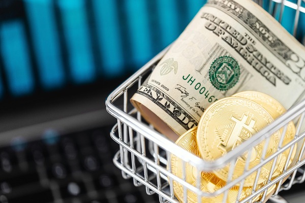 Shopping basket with dollar bills and gold crypto coins
