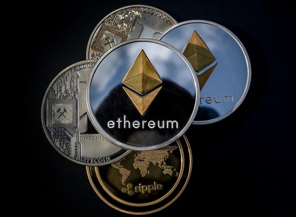 Ethereum and Ripple coins stacked on a black background